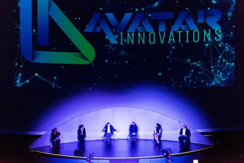 Scène avec avatar innovations logo et panneau individus assis sur scène