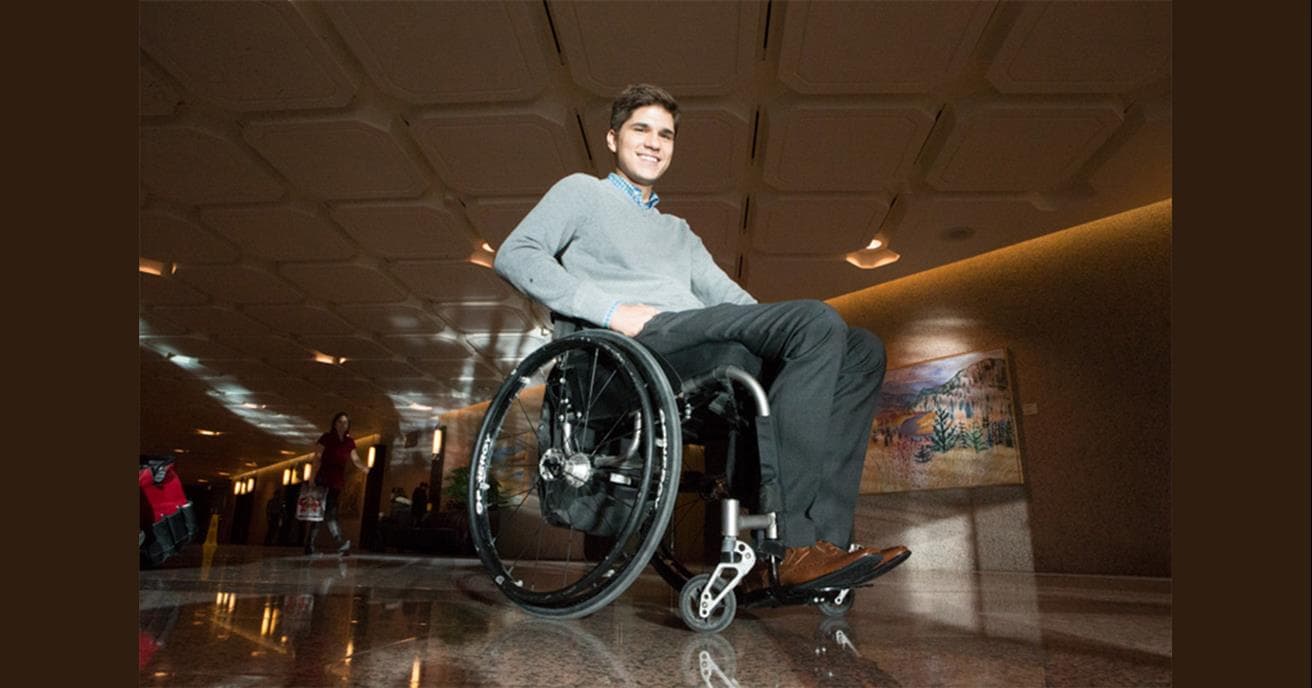 Mike Barker en fauteuil roulant, souriant.
