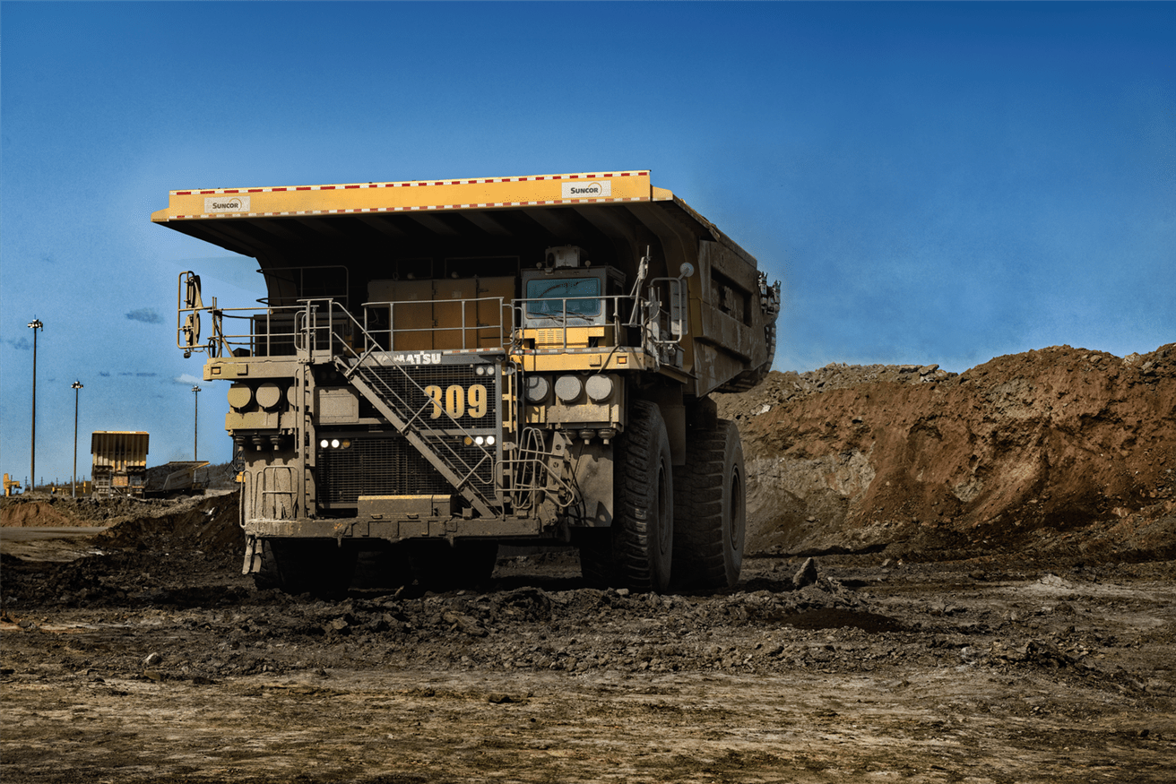 A haul truck situated at Base Plant against a blue sky. 