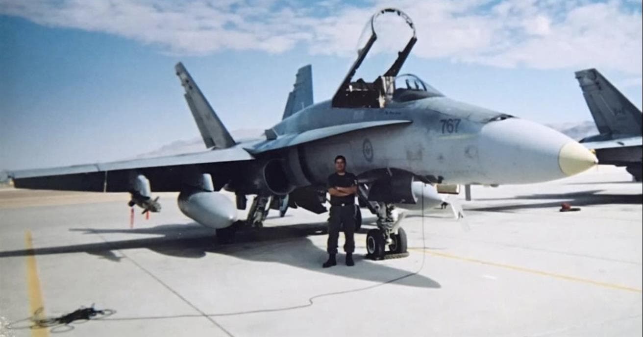 Greg Buffalo standing in front of a fighter jet  