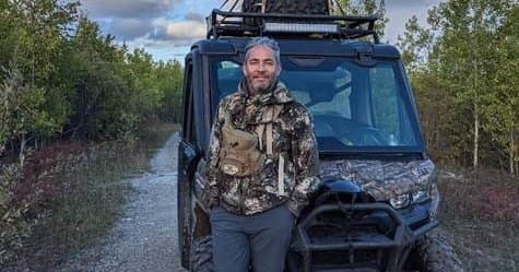 JP Gladu in camouflage gear standing in front of a camouflage buggie  
