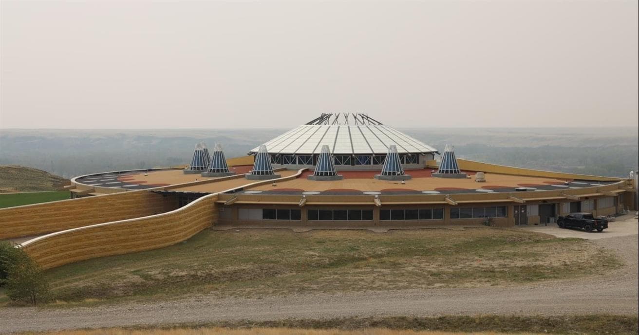 A large circular shaped building overlooking a river valley.