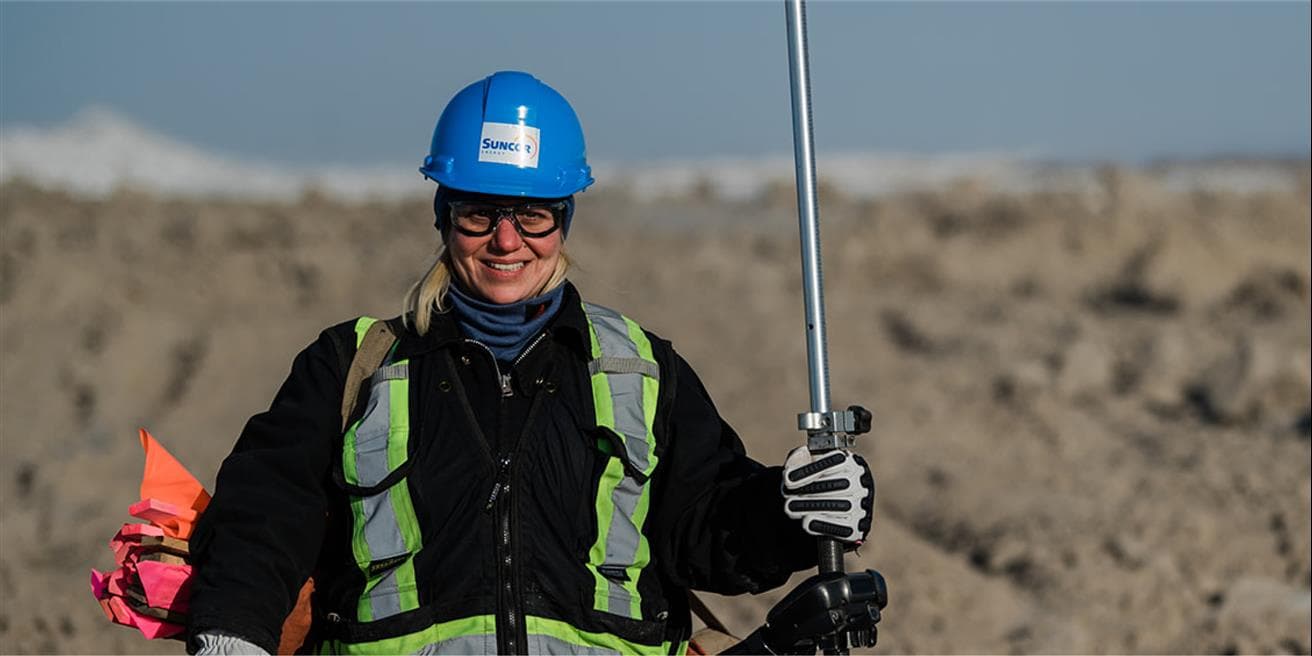 Woman standing with metal rod on site operations waiting for signal