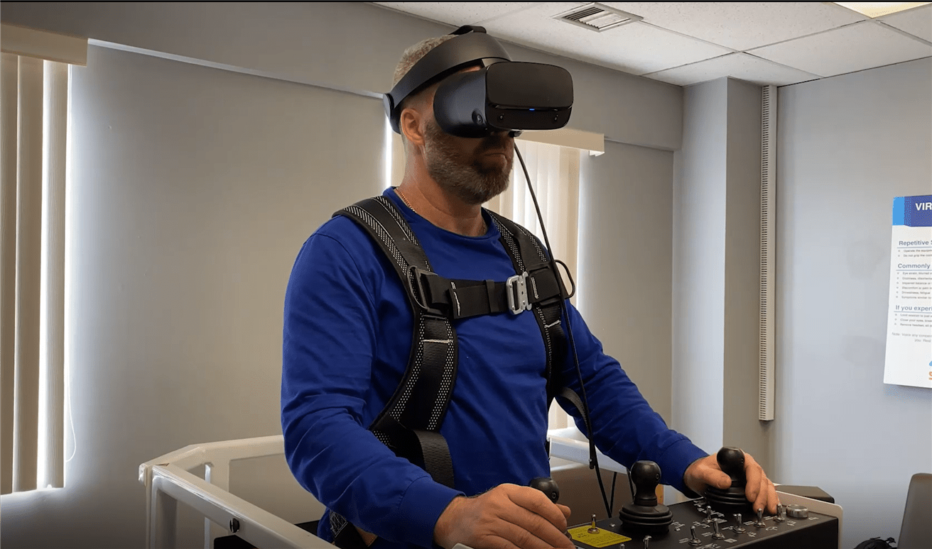 Jeff Butler, a training advisor for Suncor's Syncrude team, uses the aerial work platform virtual reality simulator.